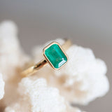 An emerald cut portrait ring set on a gold band