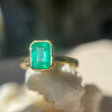 An emerald cut portrait ring set on a gold band